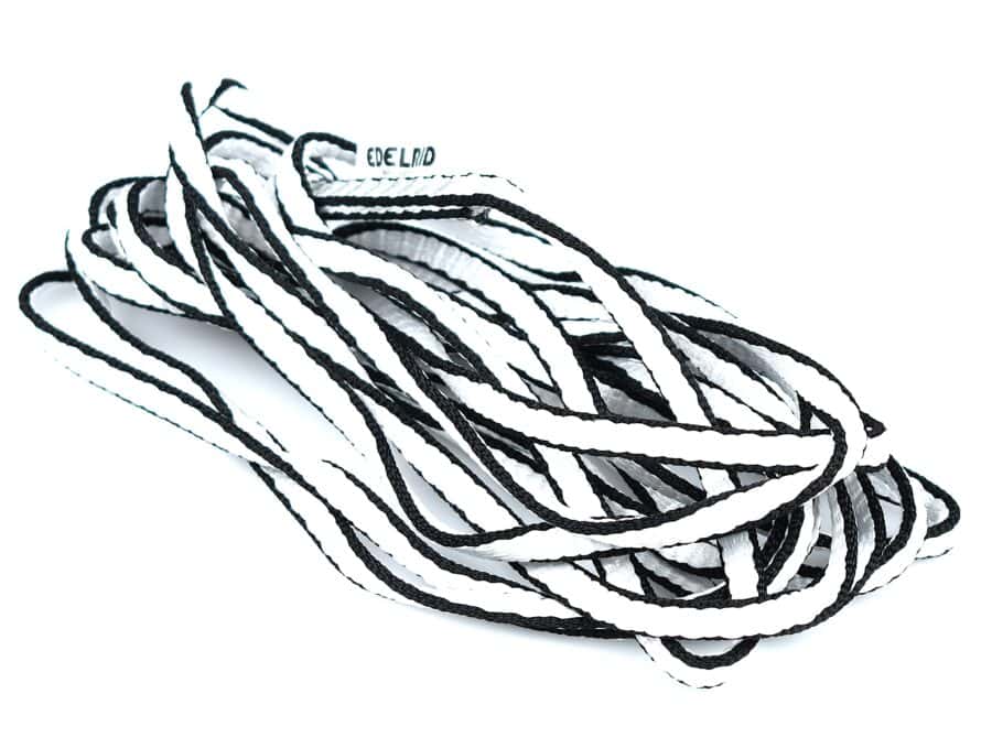 A tangled pile of black and white shoelaces reminiscent of a fire rescue team's dedicated precision.
