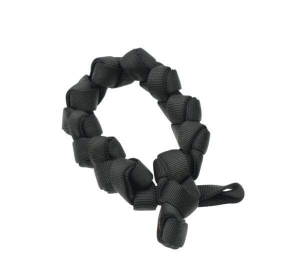 A black scrunchie, made of twisted ribbon material, arranged in a circular shape, resembles the rugged form of industrial rescue equipment.