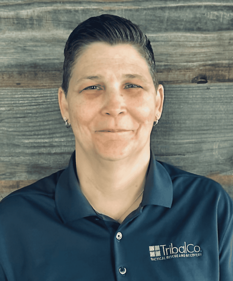 A person with short hair wearing a dark gray polo shirt with 